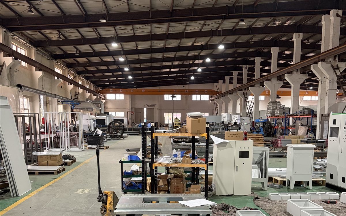 Inside LANSGRID's manufacturing facility, with cabinet frames, metal panels and production equipment