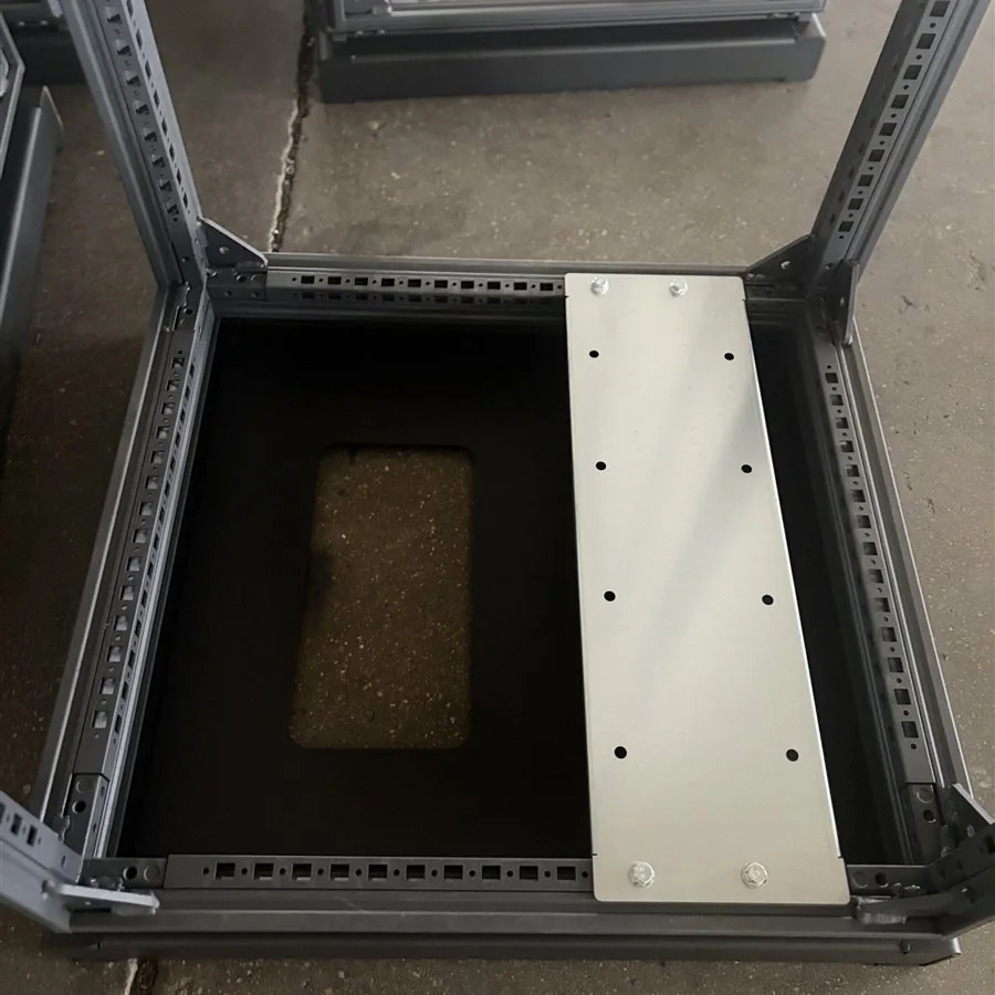 Cabinet base with perforated mounting rails and bolted metal cross-member