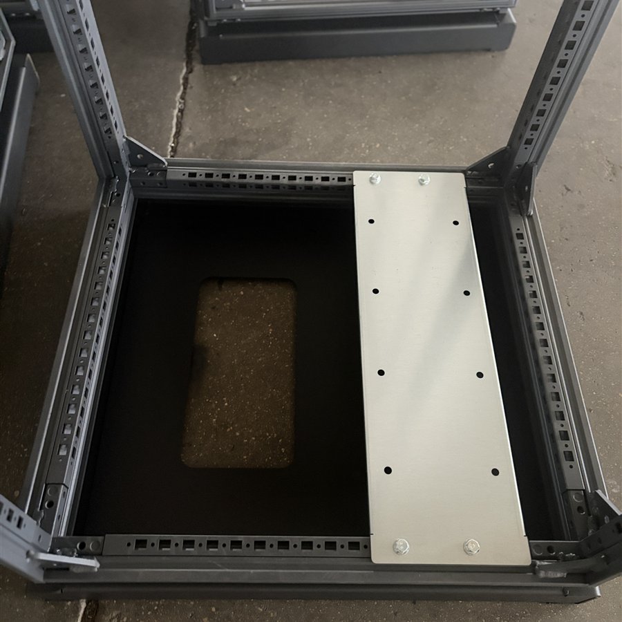Cabinet base with perforated mounting rails and bolted metal cross-member